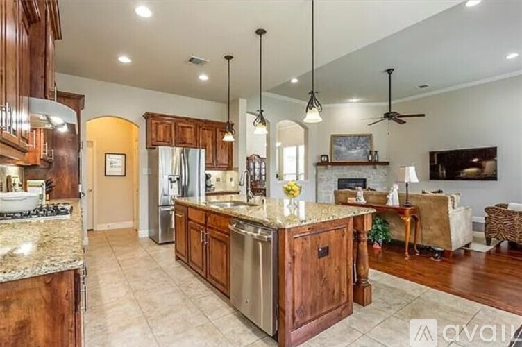 A kitchen with wooden cabinets and a marble countertop.