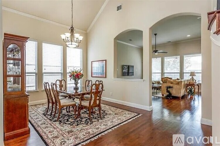 A dining room with a wooden table and chairs.