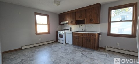 A kitchen with wooden cabinets and a white stove top oven.
