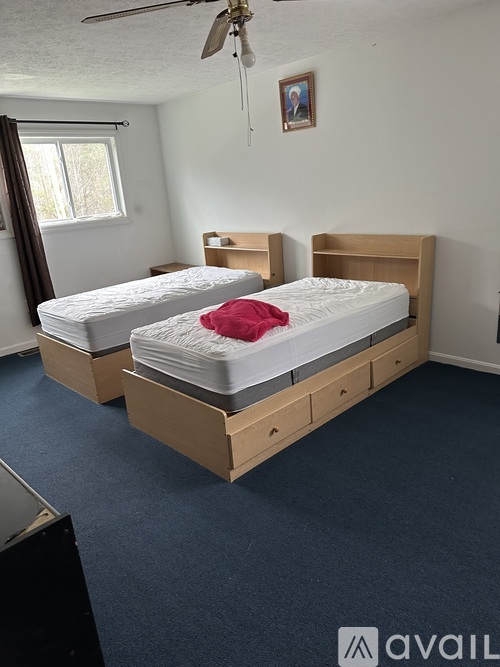 A bedroom with two beds and a ceiling fan.
