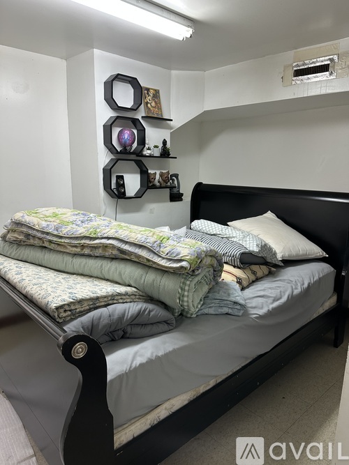 A bed with a black headboard and a white pillow is in the image.
