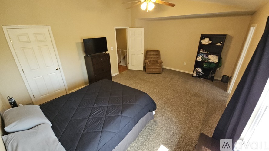A bedroom with a large bed and a flat screen TV.