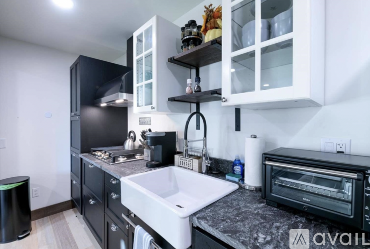 A kitchen with black cabinets and white appliances.
