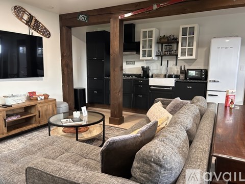 A modern living room with a grey sofa and a glass coffee table.