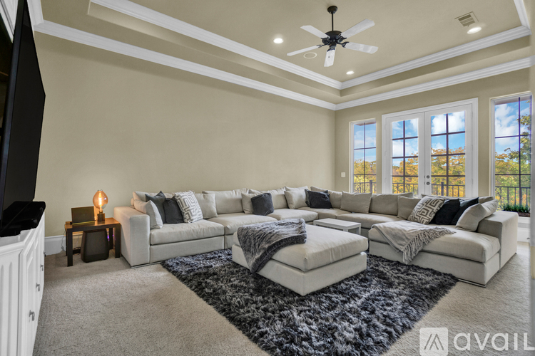 A spacious living room with a large sectional sofa and a rug in the center.