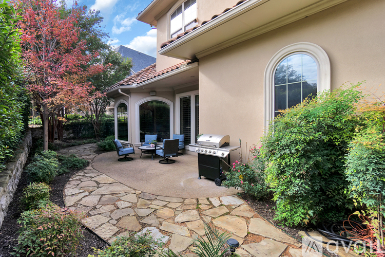 A patio with a stone walkway and a grill.
