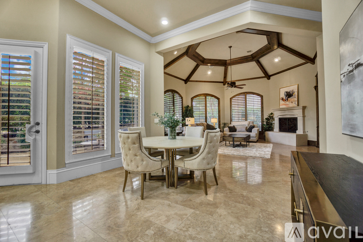 A dining room with a table set for four and a fireplace in the background.