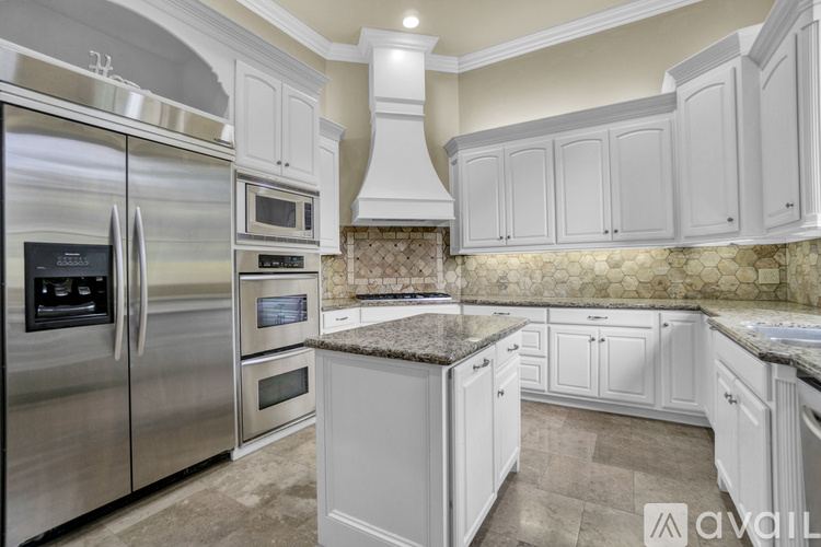 A kitchen with white cabinets and a granite countertop.