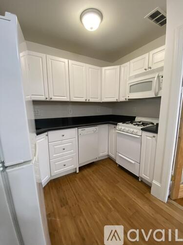A kitchen with white cabinets and appliances.
