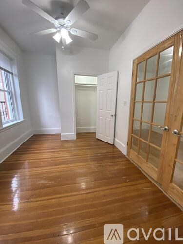 A room with wooden floors and a ceiling fan.