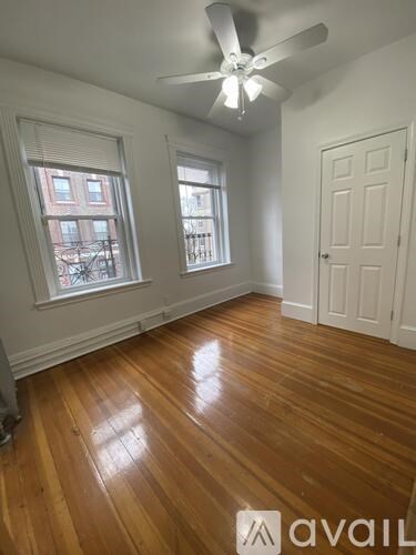 A room with wooden floors and a ceiling fan.