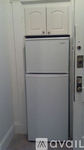 A white fridge in a small room.