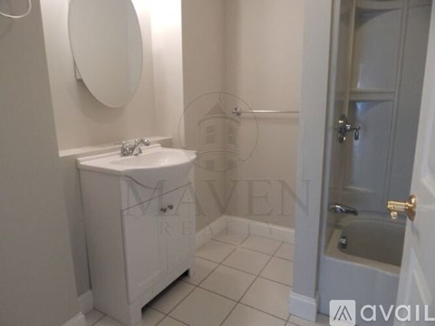 A white bathroom with a sink and a mirror.