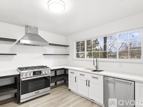 A modern kitchen with a stainless steel oven and white cabinets.