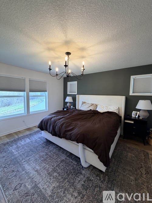 A bedroom with a large bed and a chandelier.