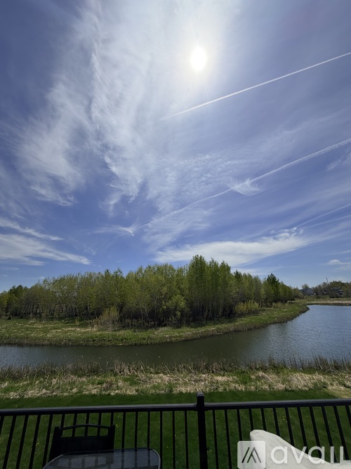 A sunny day with a river and trees in the distance.