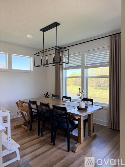 A dining room with a wooden table and chairs.
