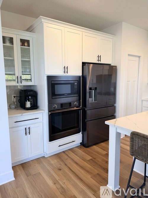 A kitchen with a white table and black appliances.