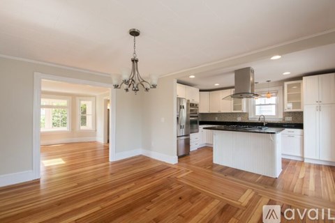 A kitchen with wooden floors and white cabinets is available for rent.