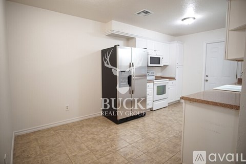 A kitchen with a deer head on the fridge and a counter top.