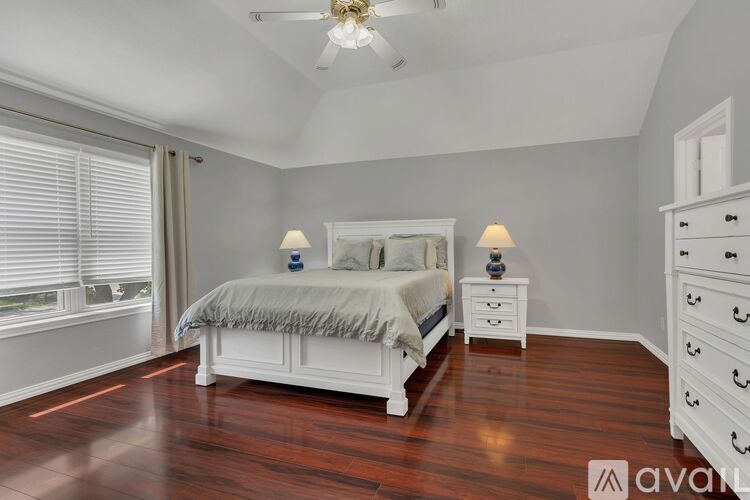 A bedroom with a large bed and a dresser.