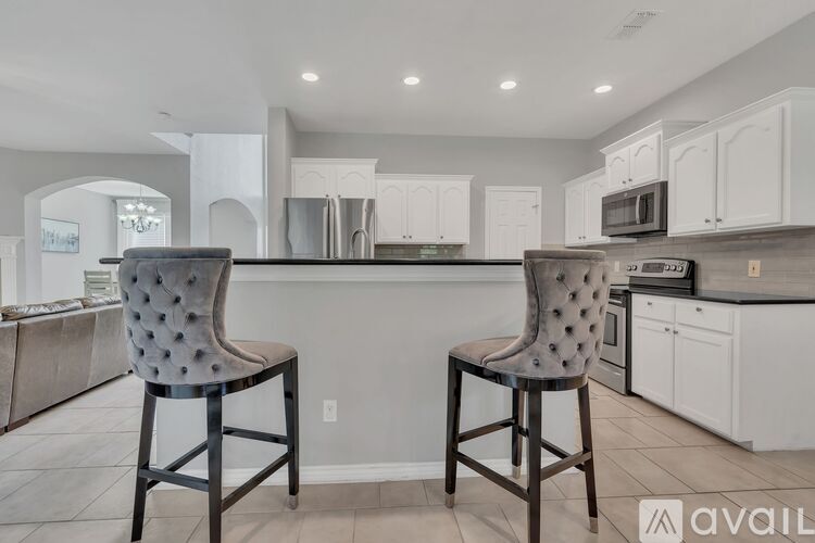 Two chairs with a patterned backrest are placed in a kitchen.