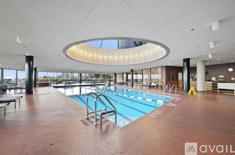 A large indoor swimming pool with a circular light fixture above it.