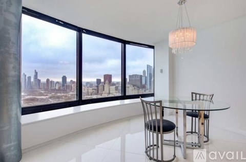 A modern dining room with a glass table and chairs and a view of the city skyline.