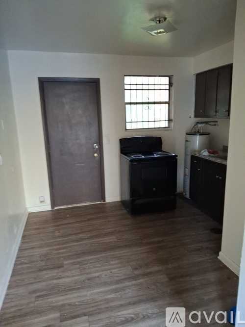 A room with a wooden floor and a brown door.