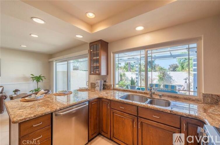 A kitchen with wooden cabinets and a granite countertop.