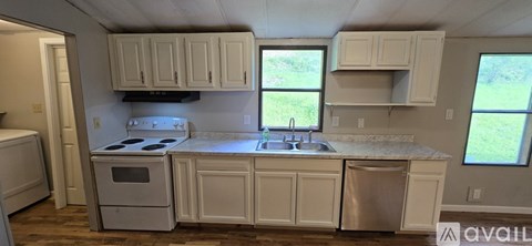 A kitchen with white cabinets and appliances.