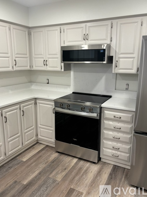 A kitchen with white cabinets and a stainless steel oven.