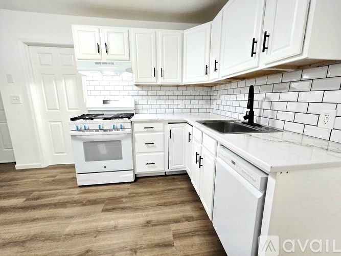 A kitchen with white cabinets and a white oven.