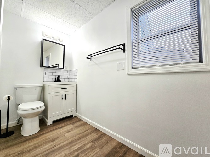 A bathroom with a toilet, sink, and a mirror.