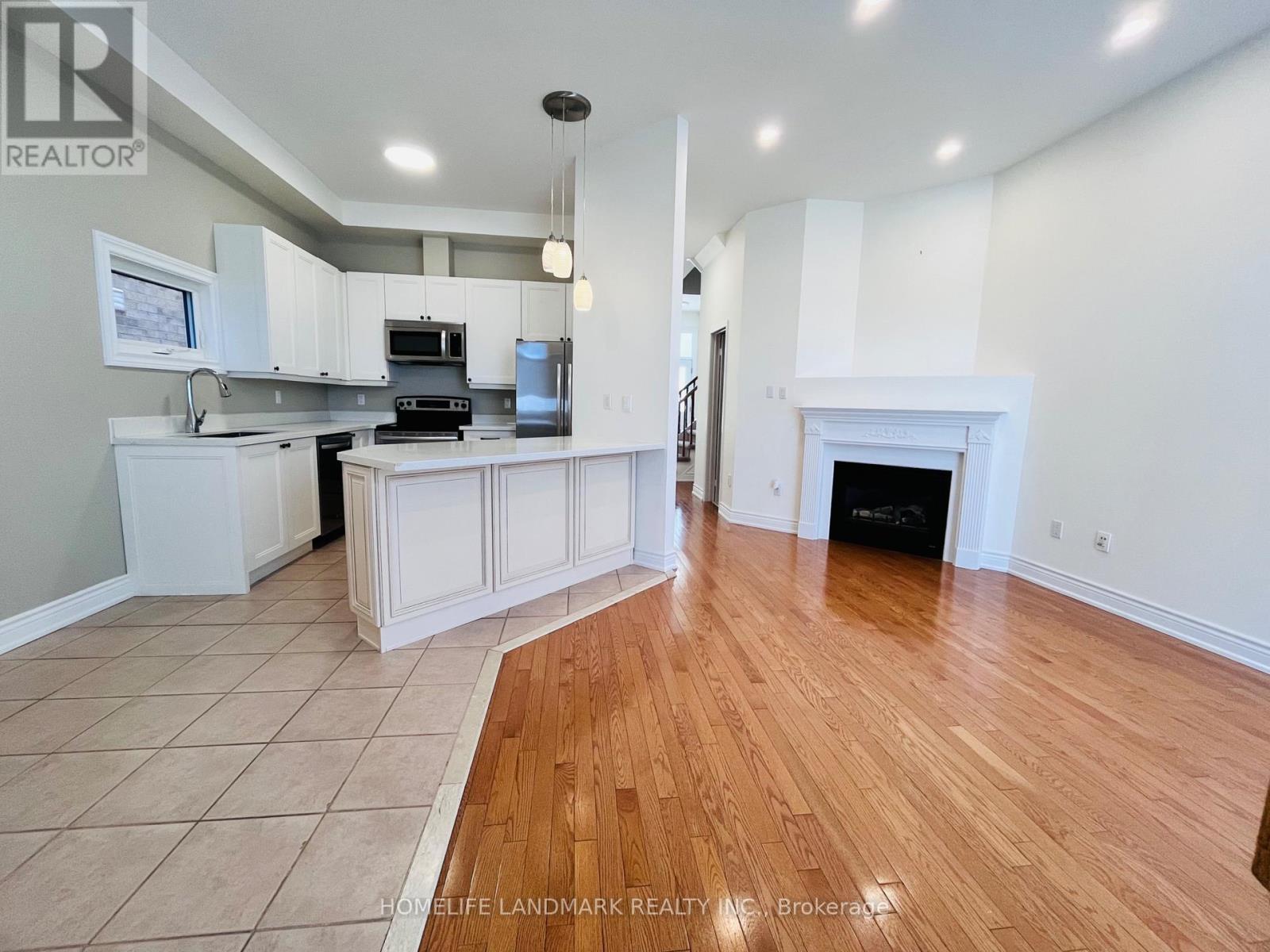A spacious kitchen with white cabinets and a wood floor.
