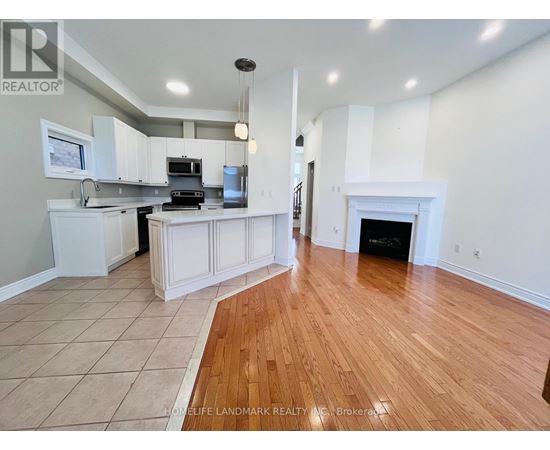 A spacious kitchen with white cabinets and a wood floor.