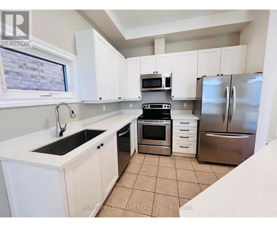 A kitchen with white cabinets and a stainless steel refrigerator.