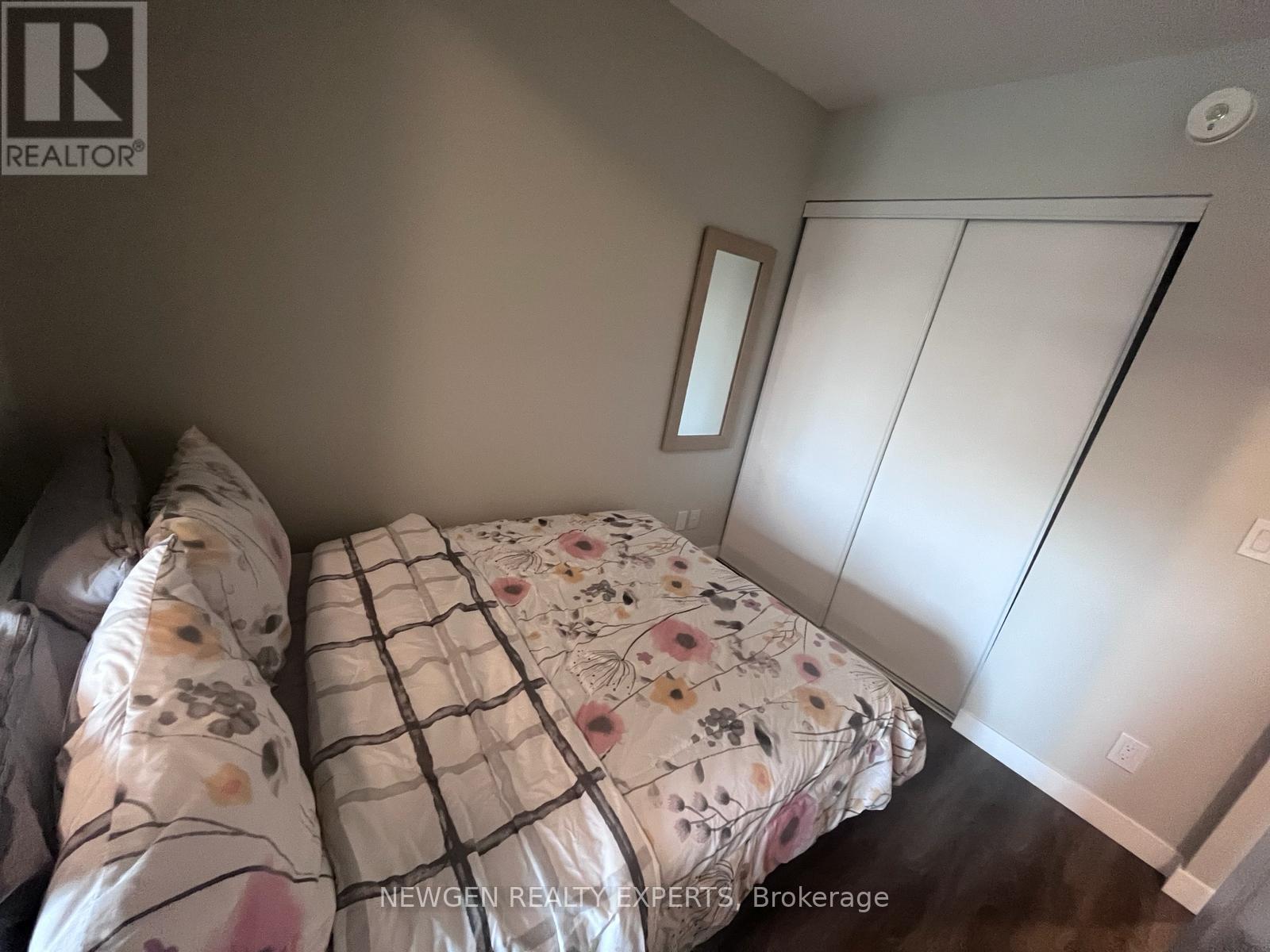 A bedroom with a bed and a mirror on the wall.