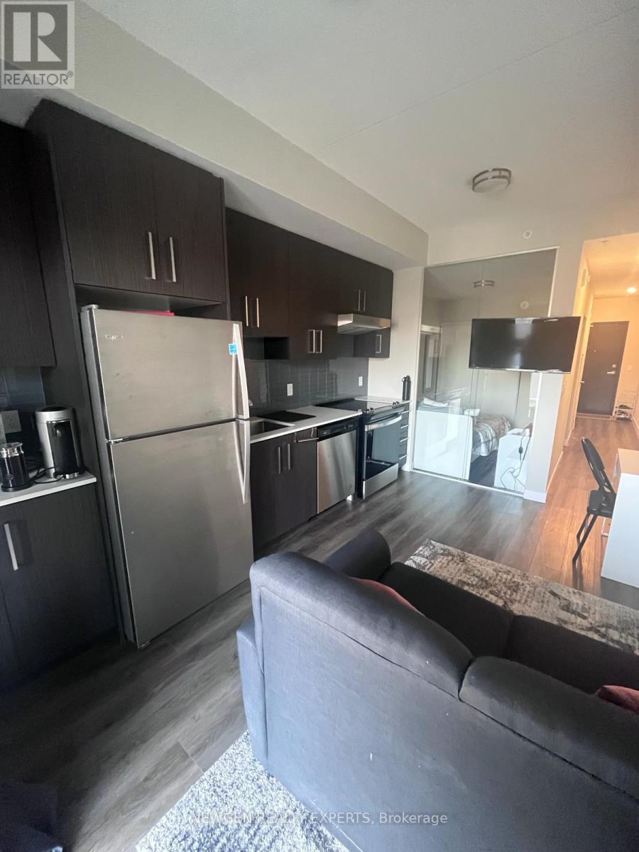 A modern kitchen with dark wood cabinets and stainless steel appliances.