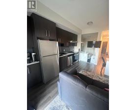 A modern kitchen with dark wood cabinets and stainless steel appliances.