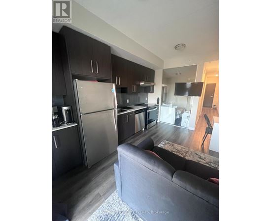 A modern kitchen with dark wood cabinets and stainless steel appliances.