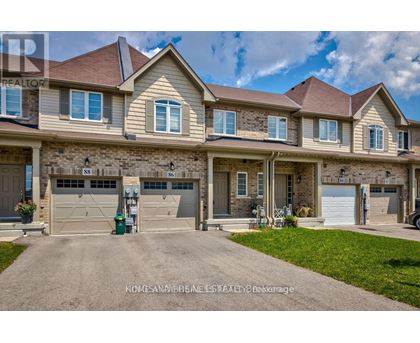 A large, well-maintained house with a driveway in front.