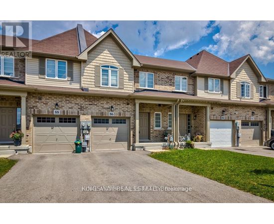 A large, well-maintained house with a driveway in front.