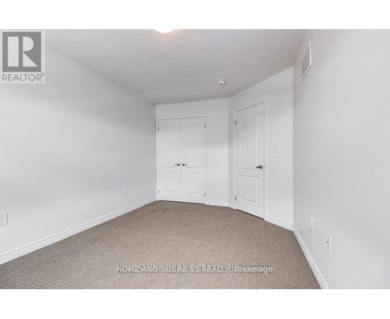 A bedroom with two doors and a carpeted floor.