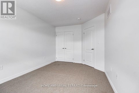 A bedroom with two doors and a carpeted floor.