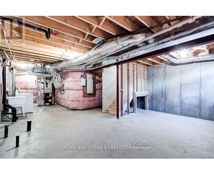A spacious unfinished room with exposed ceiling and walls.