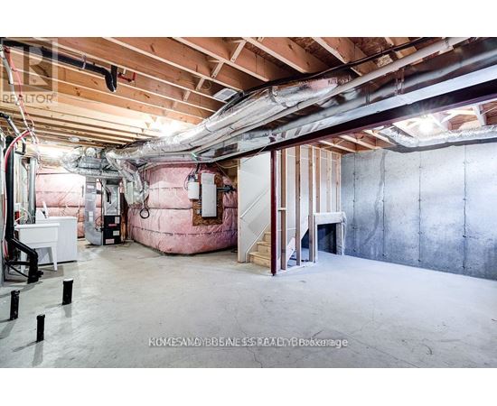 A spacious unfinished room with exposed ceiling and walls.