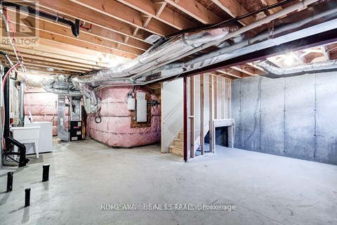 A spacious unfinished room with exposed ceiling and walls.