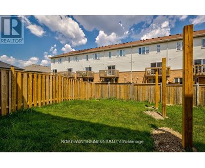 A wooden fence surrounds a grassy area in front of a building.