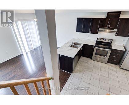 A modern kitchen with dark wood cabinets and stainless steel appliances.
